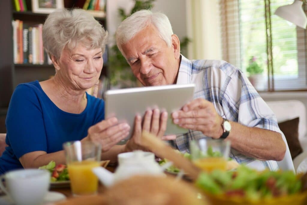 two old persons holding the tablet