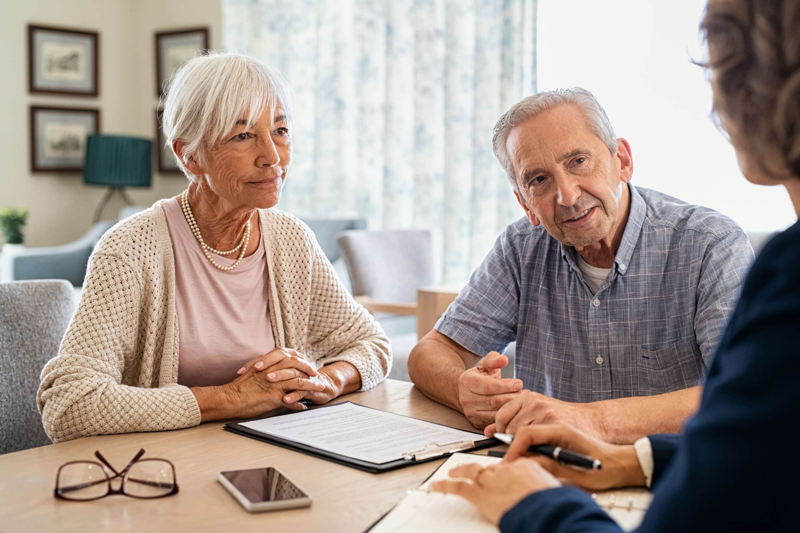 Senior couple chatting with the advisor of real estate