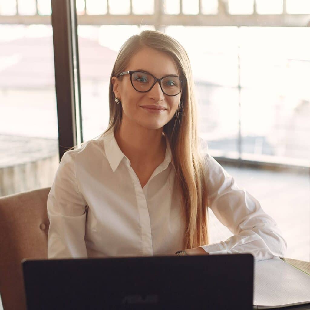 A woman wearing glasses sits at a table