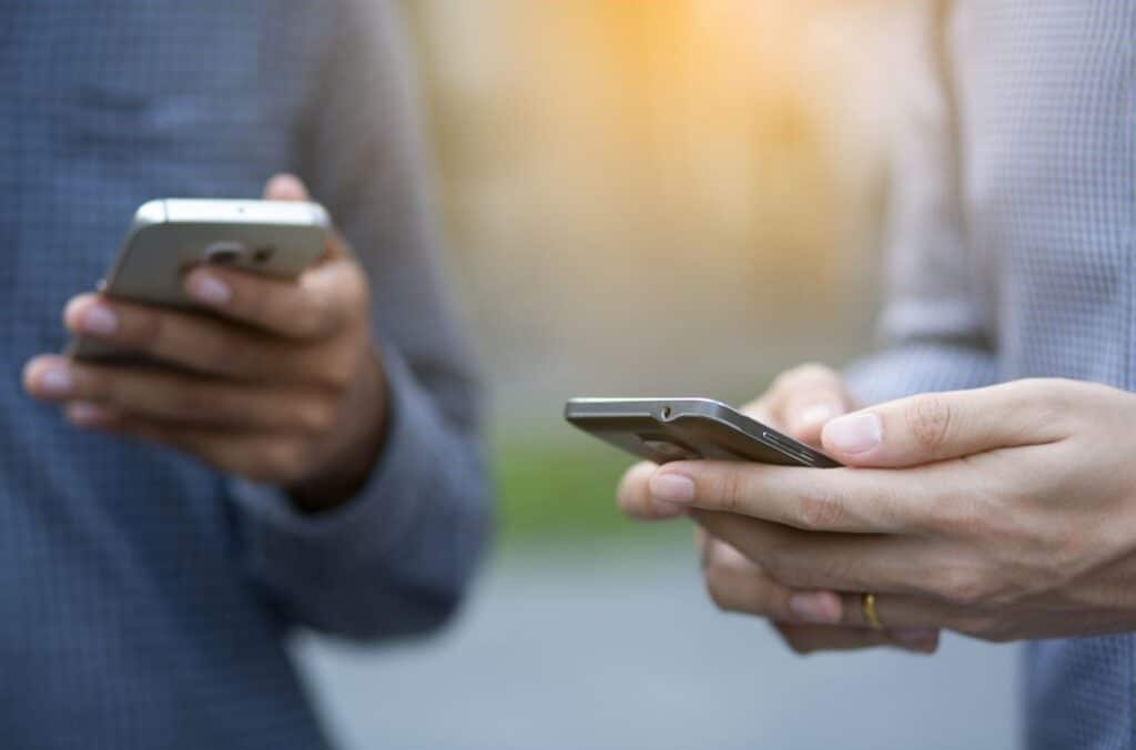 Two men with cellphones in hand